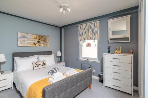 a bedroom with a king sized bed and a dresser at Historic Location, Private Parking, Ground Floor Luxury Flat in Aberdeen