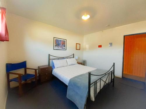 a bedroom with a bed and a nightstand and a bed sidx sidx sidx sidx at Tongariro River Retreat in Turangi