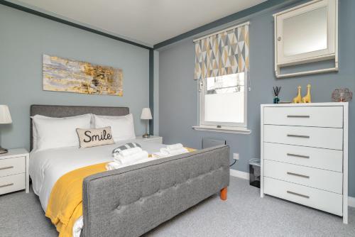 a bedroom with a bed and a white dresser at Historic Location, Private Parking, Ground Floor Luxury Flat in Aberdeen