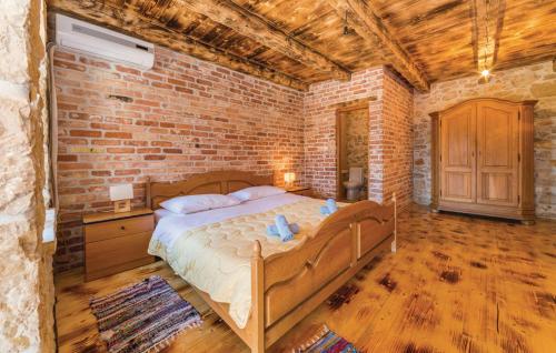 1 dormitorio con 1 cama grande en una pared de ladrillo en Luxury Villa Maria with Pool en Galovac