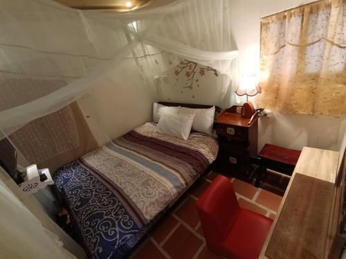 a small bedroom with a bed and a night stand at 彼岸古厝民宿-包棟優先--Biiann B&B in Jinning