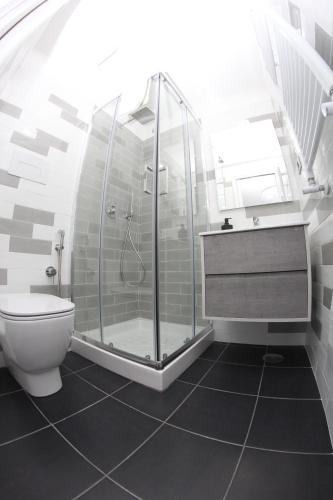 a bathroom with a shower and a toilet at Mondo Suites Apartments in Naples