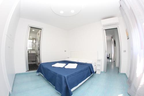 a white room with a bed and a mirror at Mondo Suites Apartments in Naples