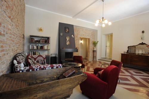 a living room with red chairs and a brick wall at Palazzo Scura in Vaccarizzo Albanese