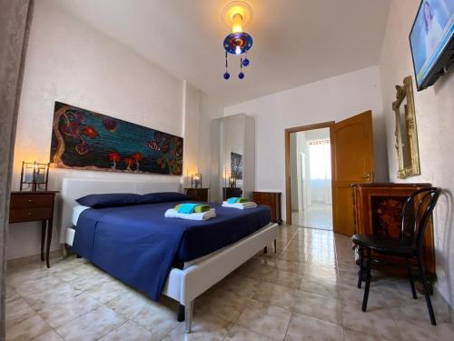 sypialnia z niebieskim łóżkiem i telewizorem w obiekcie Bed Anthos Porto Cesareo w mieście Porto Cesareo