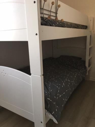 a white bunk bed with a black comforter at Face à la mer à Cabourg in Cabourg