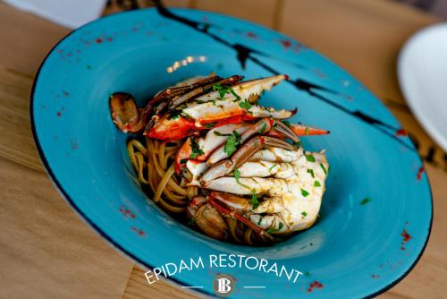 a blue plate of food with shrimp and pasta at Illyrian Boutique Hotel in Sarandë
