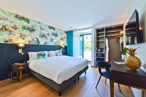 Cette chambre comprend un grand lit et un bureau. dans l'établissement Hôtel La Villa Port d'Antibes & Spa, à Antibes
