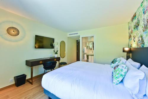 a bedroom with a white bed and a desk at Hôtel La Villa Port d'Antibes & Spa in Antibes