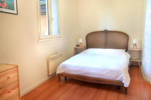 um quarto com uma cama com uma cabeceira em madeira e uma janela em Appartement idéal en plein centre ville proche lac em Annecy