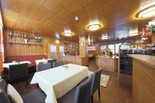 una sala da pranzo con tavolo e sedie bianchi di Ruhwarder Mühle a Ruhwarden