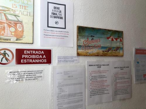 a wall with posters and signs on it at Fonte da Telha Beach Hostel in Costa da Caparica