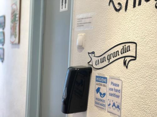 a sign on a wall that reads a gun club at Fonte da Telha Beach Hostel in Costa da Caparica