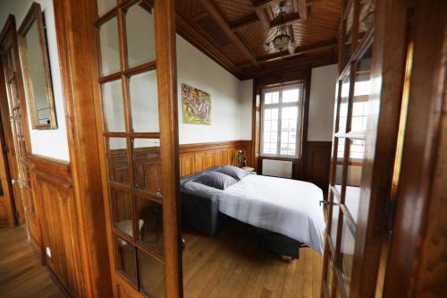 a bedroom with a bed in the corner of a room at Gite Logis des Fontaines in Raon-lʼÉtape