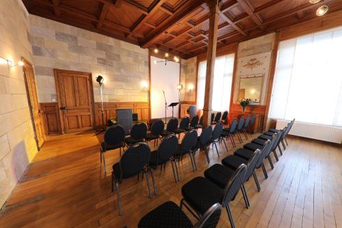 a large room with chairs and a stage in it at Gite Logis des Fontaines in Raon-lʼÉtape