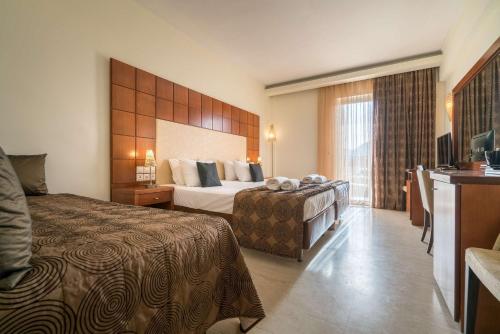 Un pat sau paturi într-o cameră la Zante Park Resort & Spa BW Premier Collection