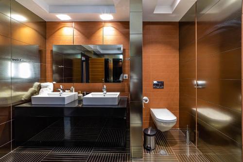 a bathroom with two sinks and a toilet at NIAN villa sea in Drosia