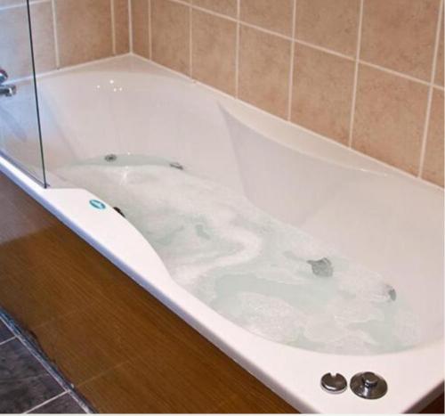 a bathtub with a white tub and a white toilet at Rooms at 1703 in Dunfermline