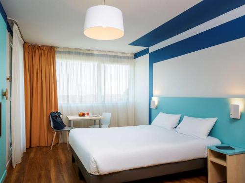 เตียงในห้องที่ Aparthotel Adagio Access Strasbourg Illkirch