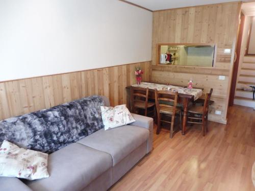 ein Wohnzimmer mit einem Sofa und einem Tisch in der Unterkunft Appartamento 90 con vista e balcone in Breuil-Cervinia