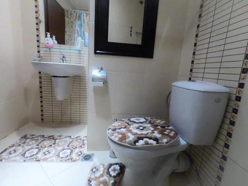 a bathroom with a toilet covered in donuts on the floor at Green Life Pool View Apartment in Sozopol
