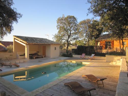 - une piscine avec des chaises et une maison dans l'établissement Les Cabanes de Carelle, à Aspères