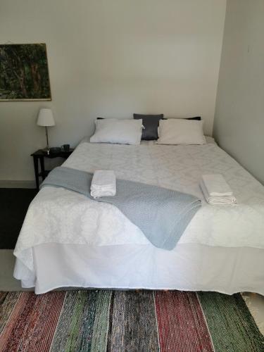 a bedroom with a large bed with white sheets and pillows at Guesthouse Lokinlaulu in Kotka