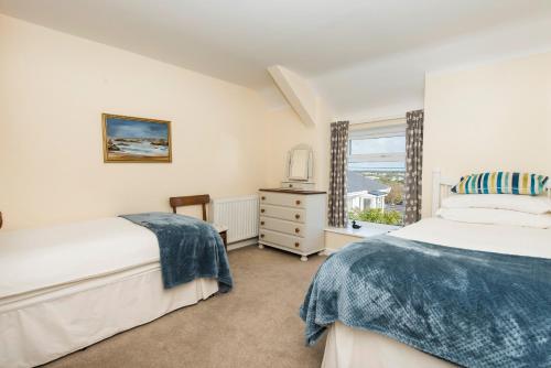a bedroom with two beds and a window at Porth Diana House - 4 Bed-Sleep10-Trearddur Bay in Trearddur
