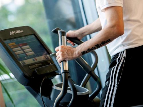 a man riding on a treadmill in a gym at Novotel Chennai OMR in Chennai