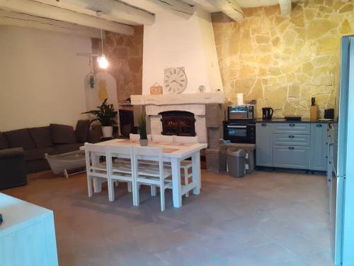 un salon avec une table et une cheminée dans l'établissement Maison vigneronne Vias centre, à Vias