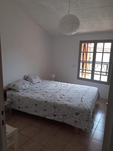 une chambre blanche avec un lit et une fenêtre dans l'établissement Maison vigneronne Vias centre, à Vias