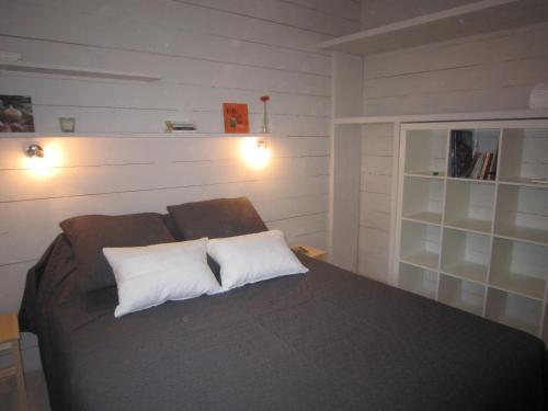 een slaapkamer met een bed met 2 witte kussens bij Les Cabanes de Carelle in Aspères