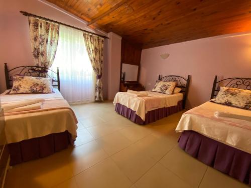 a bedroom with two beds and a window at Maviev Otel in Çeşme