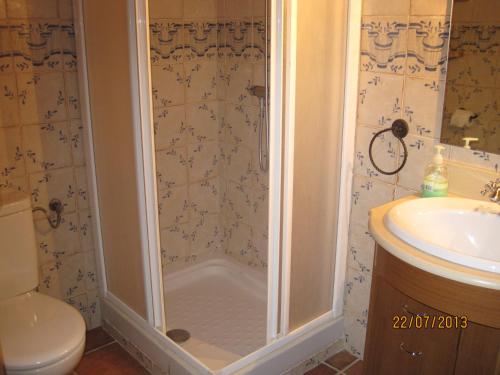 a shower in a bathroom with a toilet and a sink at Apartamentos Rurales Casa del Tio Juan in Olocau del Rey