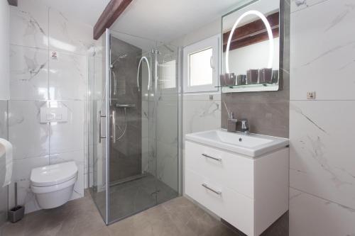 a bathroom with a toilet and a shower and a sink at Villa Rocco Private Saltwater Pool Split in Kaštela