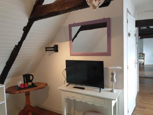 telewizor siedzący na kominku w pokoju w obiekcie Chambres d'Hôtes de la Presqu'Île w mieście Pleubian