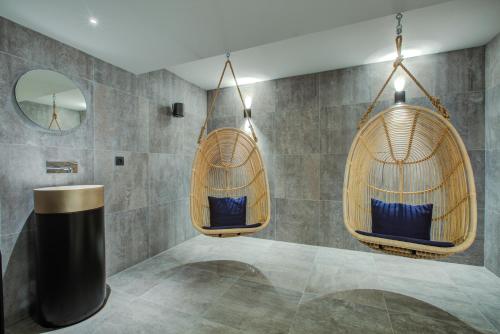 La salle de bains est pourvue de 2 chaises suspendues et d'un miroir. dans l'établissement Thedrus luxury apt, swimming pool, SPA & more, à Chamonix-Mont-Blanc