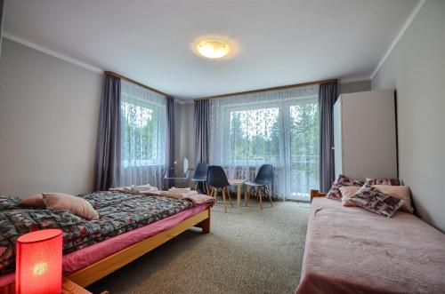 um quarto com 2 camas, uma mesa e cadeiras em Apartament ANWAN em Wisla