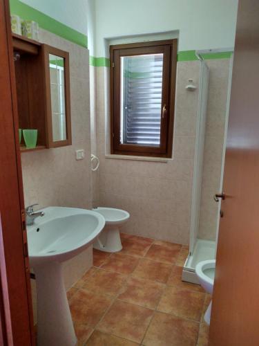 a bathroom with a sink and a toilet and a tub at Residence Ristorante Baobab in Controguerra