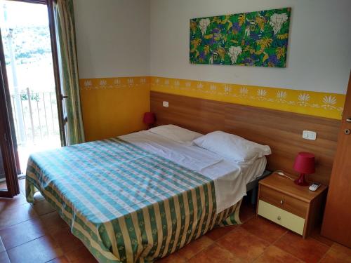 a bedroom with a bed and a painting on the wall at Residence Ristorante Baobab in Controguerra
