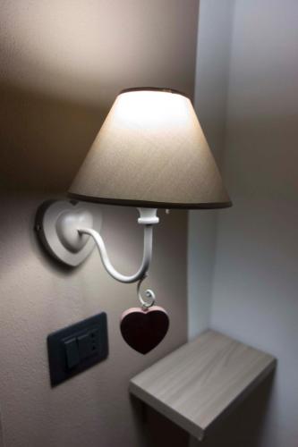 a lamp with a heart attached to a wall at B&B La casa dei cuori in Millesimo
