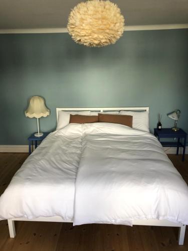a bedroom with a large white bed with two lamps at Havings skafferi in Lysekil