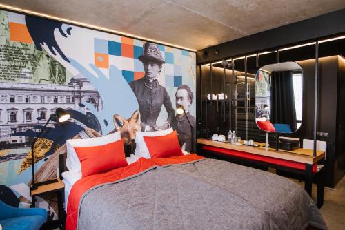 a bedroom with a bed with a painting on the wall at !FEST Hotel in Lviv