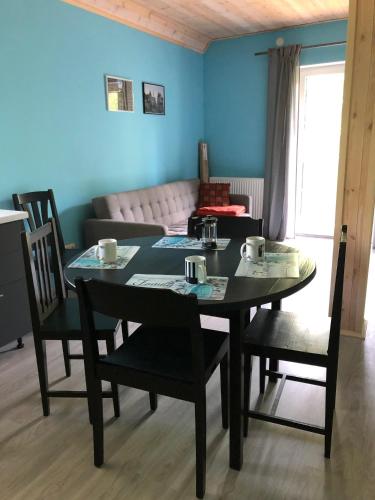 a dining room with a table and chairs and a couch at Metsalagendik in Otepää