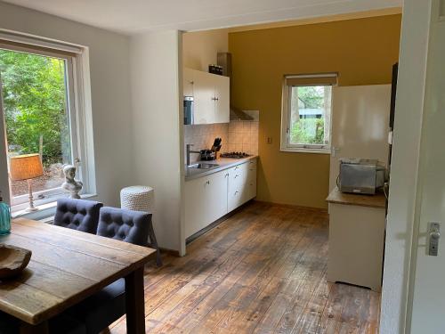 a kitchen with a table and a dining room at Huize Nuwenspete in Nunspeet