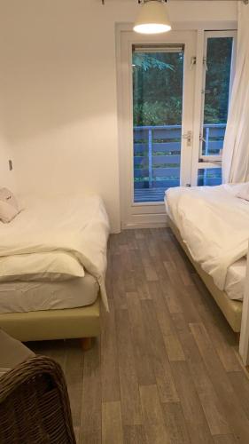 a bedroom with two beds and a window at Huize Nuwenspete in Nunspeet
