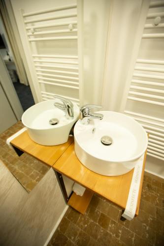 a bathroom with a white sink on a wooden table at Renato HOUSE in Târgu Jiu
