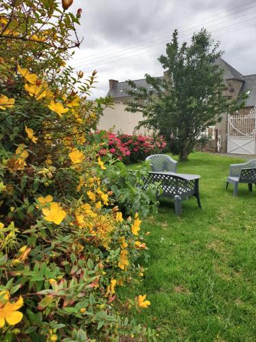 a park bench and flowers in a yard at Chambres d'Hôtes de la Presqu'Île in Pleubian