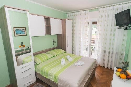 um quarto com uma cama e uma televisão em Bed and Breakfast Rooms Sandalj em Mošćenička Draga