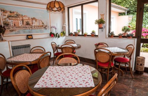 um restaurante com mesas, cadeiras e janelas em Bed and Breakfast Rooms Sandalj em Mošćenička Draga